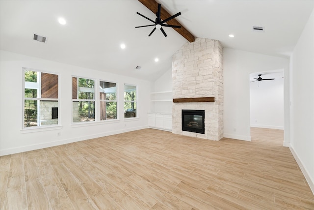 unfurnished living room featuring a fireplace, light hardwood / wood-style floors, beam ceiling, and high vaulted ceiling