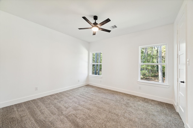 carpeted spare room featuring ceiling fan