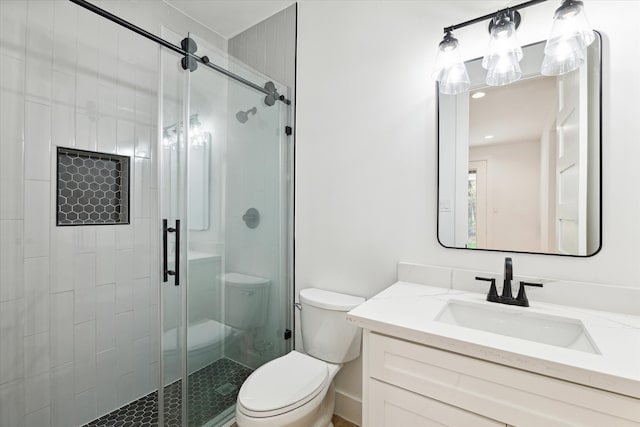 bathroom featuring an enclosed shower, vanity, and toilet