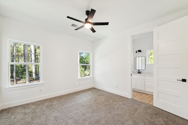 spare room with plenty of natural light, ceiling fan, and light carpet