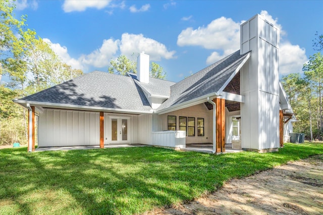 back of house featuring a lawn and french doors