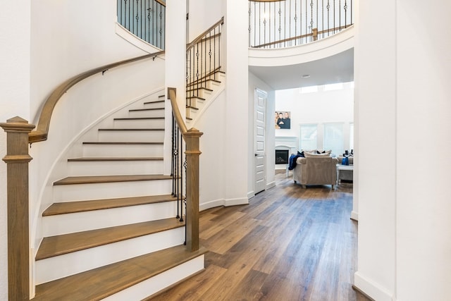 stairs with a high ceiling and hardwood / wood-style flooring