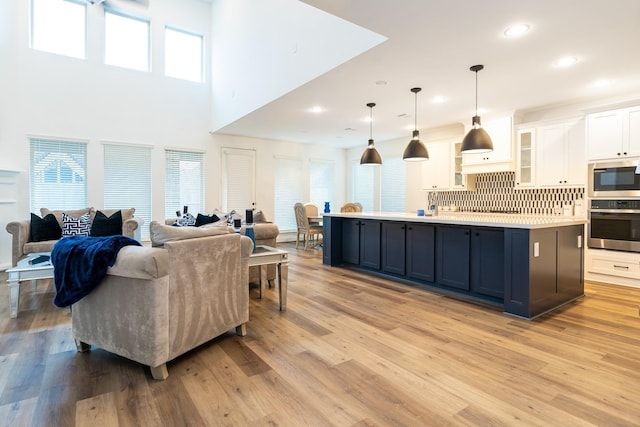 living room featuring light hardwood / wood-style flooring and a high ceiling