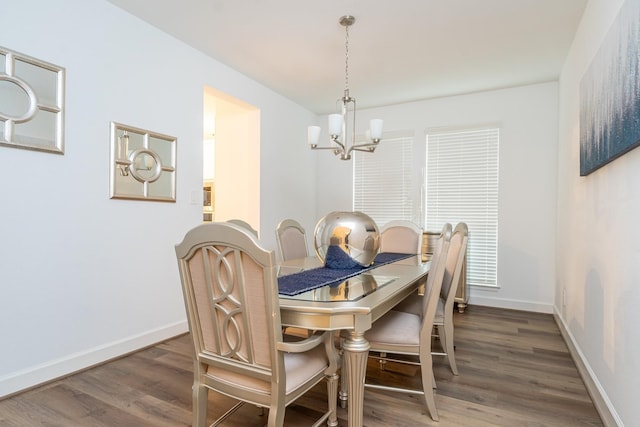 dining area with a chandelier and dark wood-type flooring