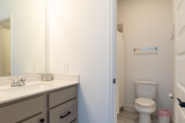 bathroom with hardwood / wood-style flooring, vanity, and toilet