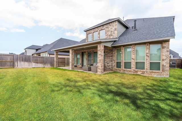 rear view of property with an outdoor living space, a patio, and a lawn