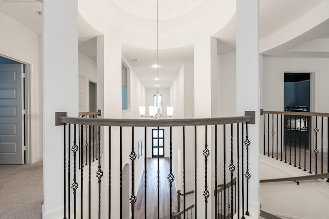 hallway featuring a chandelier and carpet flooring