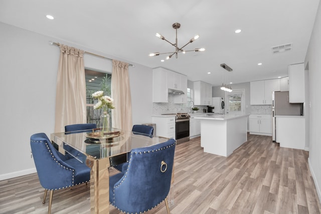 dining room with a chandelier and light wood-type flooring