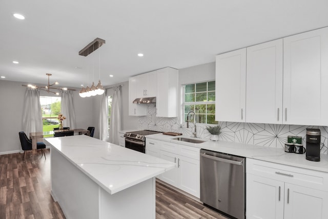 kitchen with hanging light fixtures, white cabinets, dark hardwood / wood-style flooring, a kitchen island, and appliances with stainless steel finishes