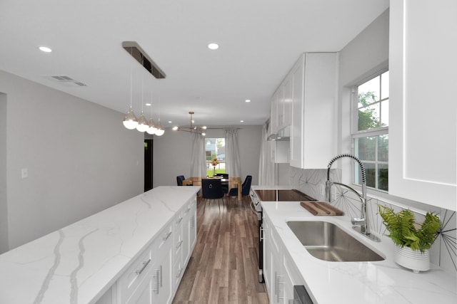 kitchen with electric range, white cabinets, and a healthy amount of sunlight