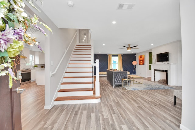 stairs with ceiling fan and wood-type flooring