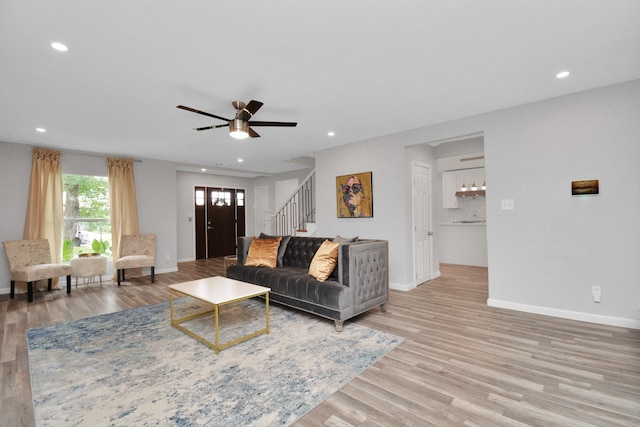 living room with ceiling fan and light hardwood / wood-style flooring