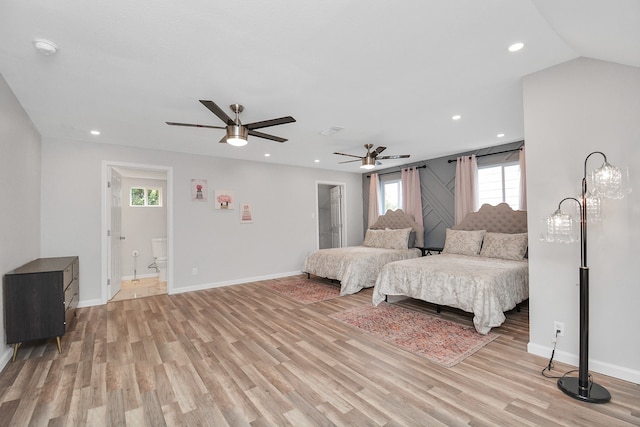 bedroom featuring ensuite bath, ceiling fan, light hardwood / wood-style floors, and vaulted ceiling