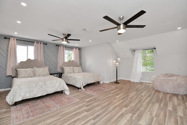 bedroom with ceiling fan, light hardwood / wood-style floors, and multiple windows