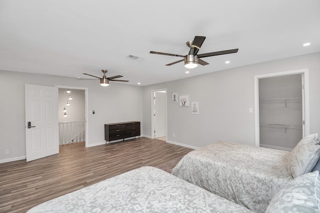 bedroom featuring hardwood / wood-style flooring, ceiling fan, a spacious closet, and a closet