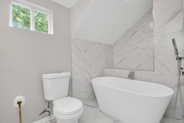 bathroom featuring a tub to relax in, toilet, and tile walls