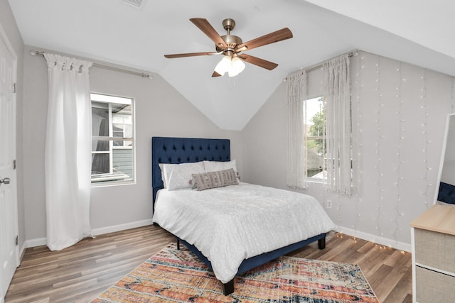 bedroom with hardwood / wood-style flooring, ceiling fan, and vaulted ceiling