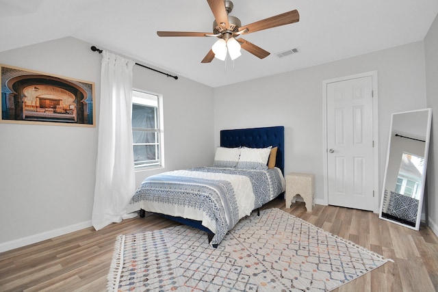 bedroom with ceiling fan, wood-type flooring, and lofted ceiling