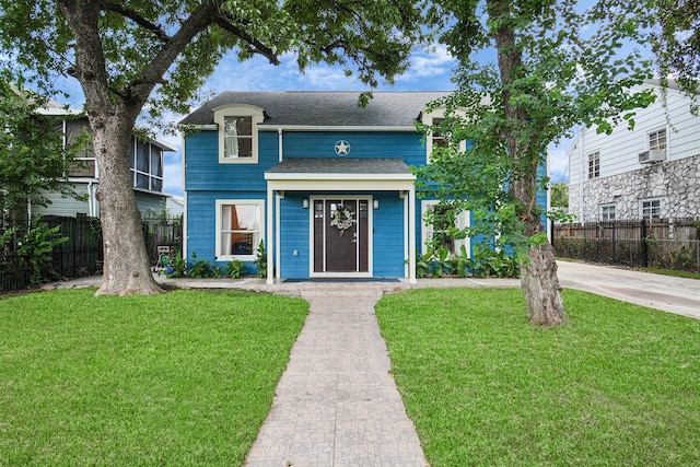 view of front of home with cooling unit and a front lawn