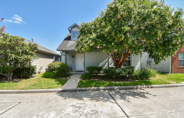 view of property hidden behind natural elements featuring a front lawn