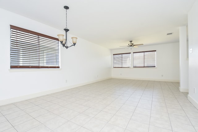 empty room featuring light tile patterned flooring and ceiling fan with notable chandelier