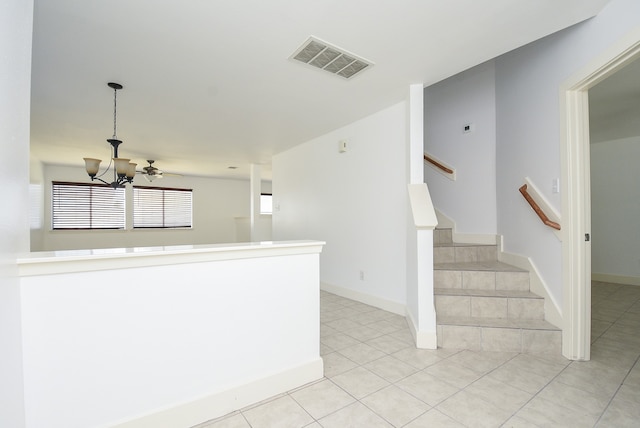 interior space featuring ceiling fan with notable chandelier and tile patterned floors