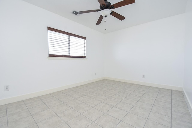 spare room with ceiling fan and light tile patterned floors