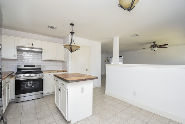 kitchen featuring stainless steel range, decorative light fixtures, white cabinets, butcher block countertops, and a kitchen island