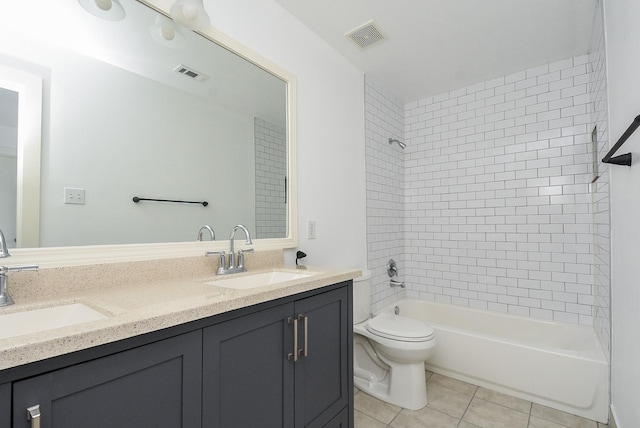 full bathroom with tile patterned floors, vanity, tiled shower / bath combo, and toilet