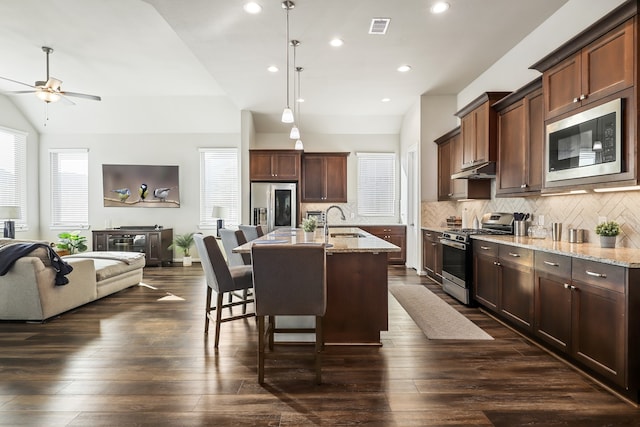 kitchen featuring stainless steel appliances, light stone counters, dark hardwood / wood-style floors, and sink