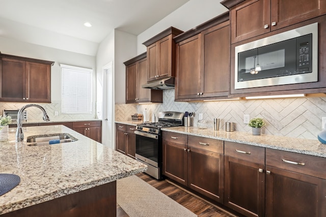 kitchen featuring sink, stainless steel appliances, tasteful backsplash, light stone counters, and dark hardwood / wood-style floors