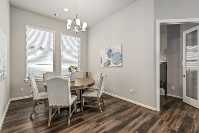 dining room with dark wood-type flooring and a notable chandelier