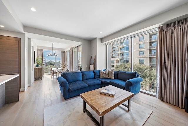 living room featuring light hardwood / wood-style flooring and an inviting chandelier