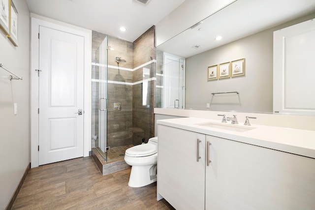 bathroom with an enclosed shower, vanity, and toilet