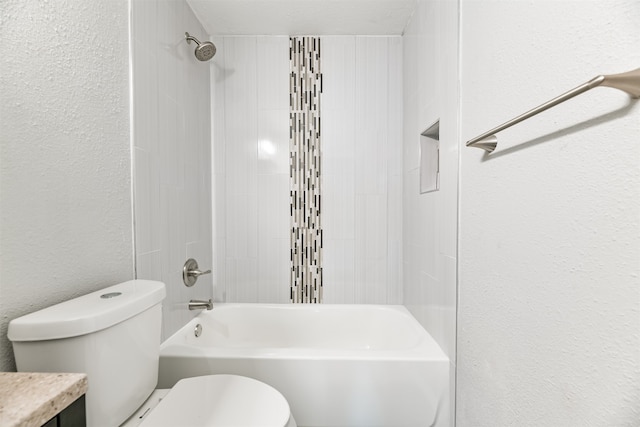 full bathroom featuring vanity, tiled shower / bath combo, and toilet