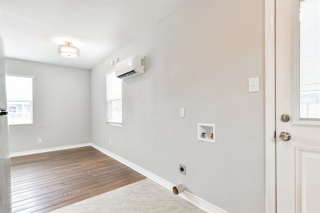 laundry room with a wall mounted AC, light wood-type flooring, a wealth of natural light, and hookup for an electric dryer