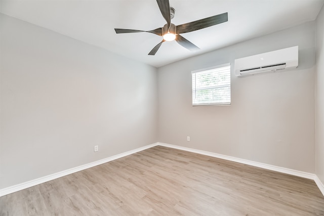 spare room with light wood-type flooring, an AC wall unit, and ceiling fan