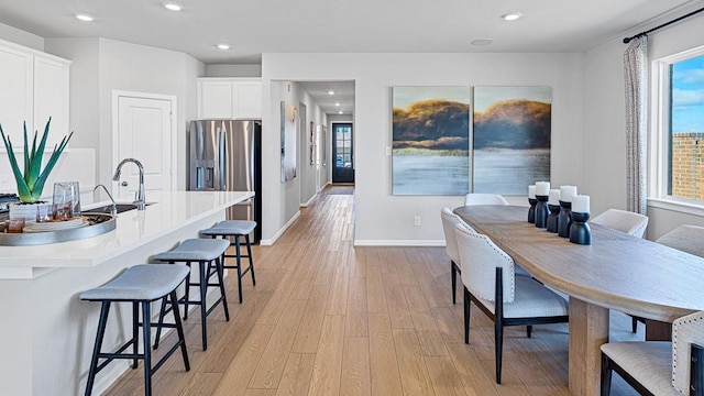 dining space featuring light hardwood / wood-style flooring and sink