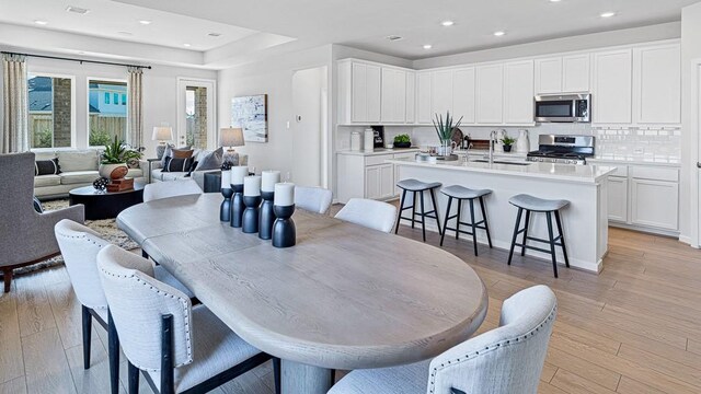 dining space with light hardwood / wood-style floors and sink