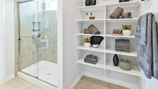 bathroom with tile patterned floors and a shower with door