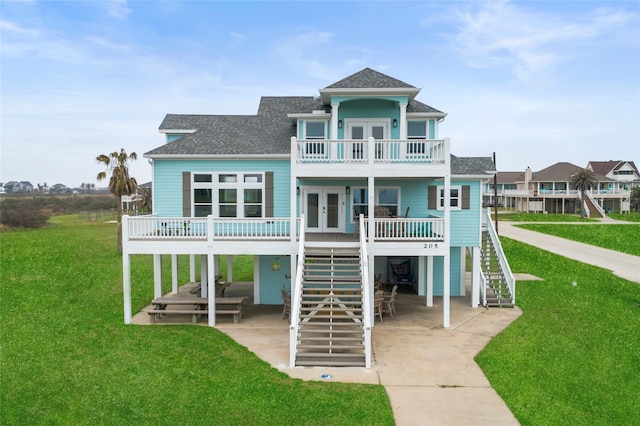 back of house featuring a yard, french doors, a balcony, and covered porch