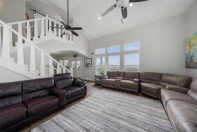 living room featuring french doors, ceiling fan, wood-type flooring, a barn door, and high vaulted ceiling