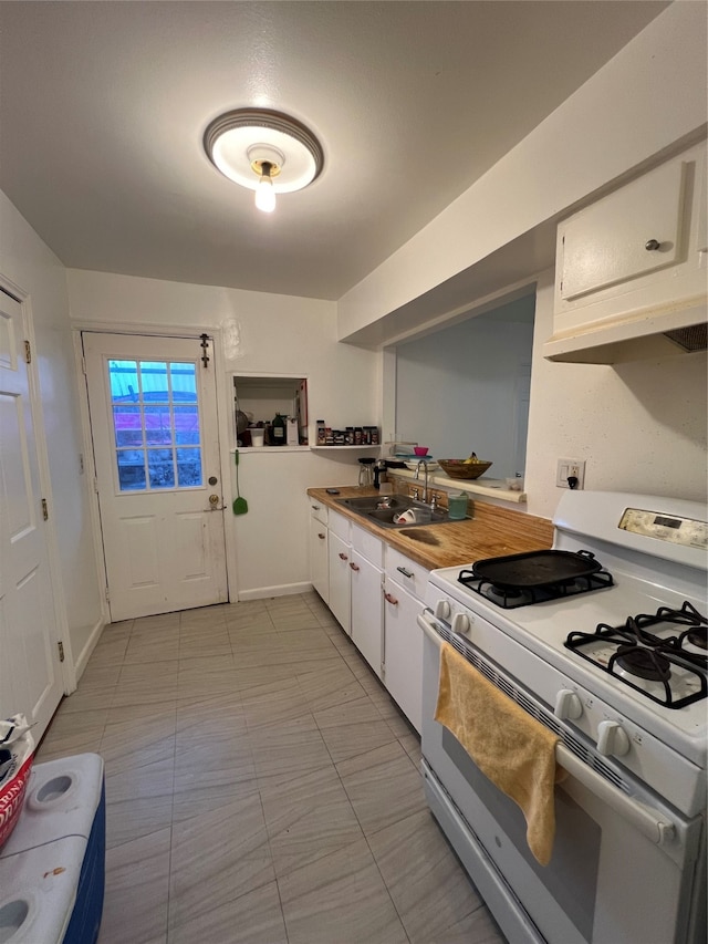 kitchen with white cabinetry, white gas stove, and sink