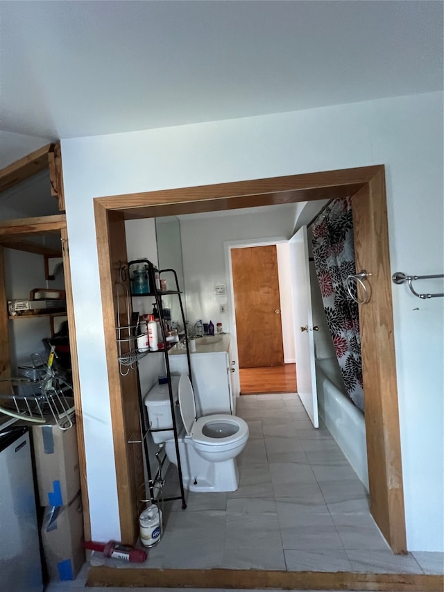 full bathroom featuring tile patterned flooring, vanity, toilet, and shower / bath combo with shower curtain