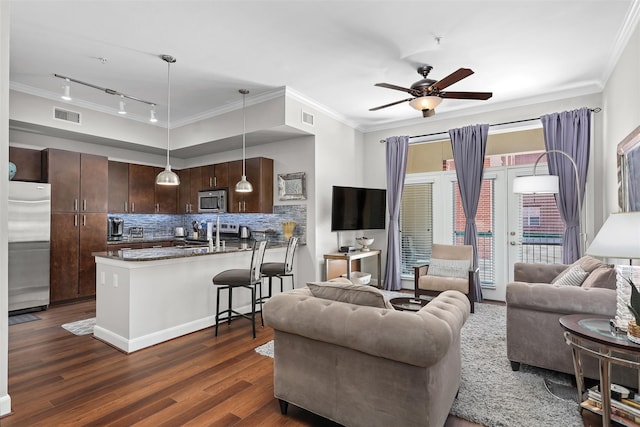 living room with track lighting, ceiling fan, crown molding, sink, and dark hardwood / wood-style floors