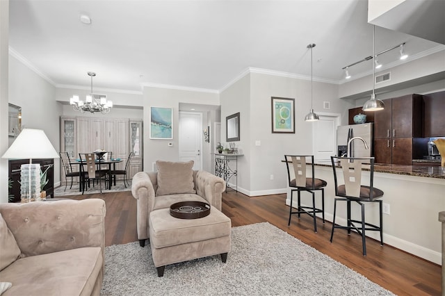 300 St Joseph Pkwy Unit 115, Houston, TX 77002 - living room with a chandelier, dark wood-style floors, baseboards, ornamental molding, and rail lighting