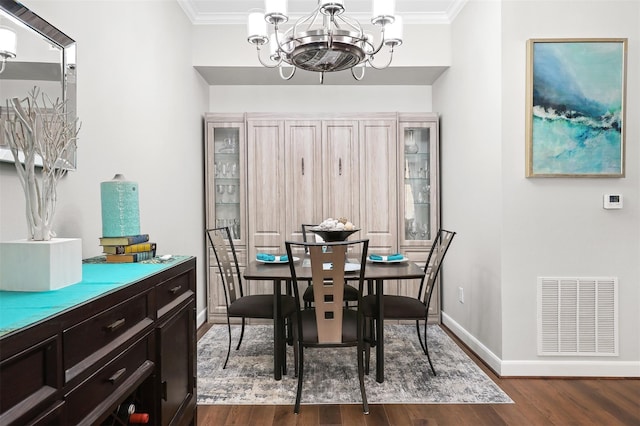 300 St Joseph Pkwy Unit 115, Houston, TX 77002 - dining space featuring baseboards, dark wood-style flooring, a chandelier, and crown molding
