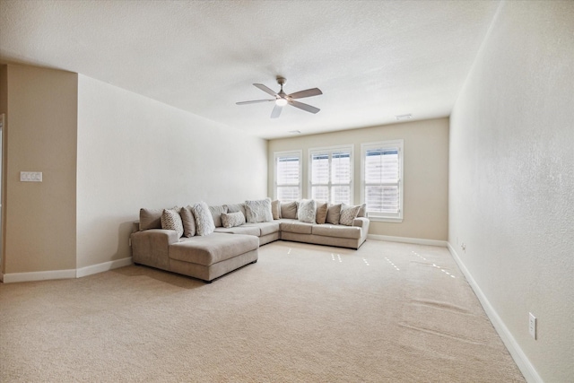 living room featuring a textured ceiling, carpet floors, and ceiling fan