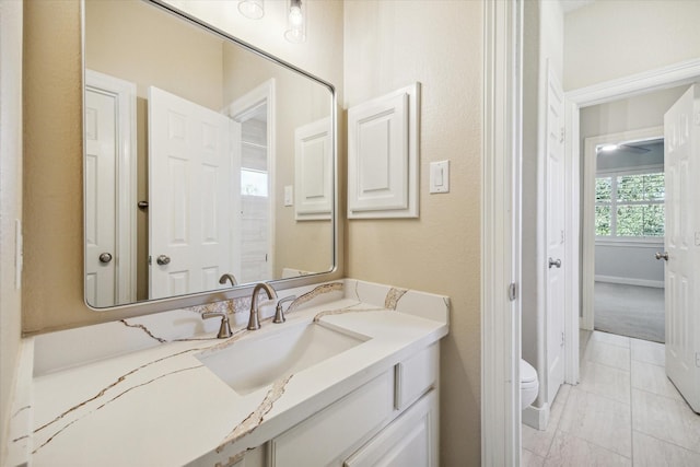 bathroom featuring tile patterned flooring, vanity, and toilet