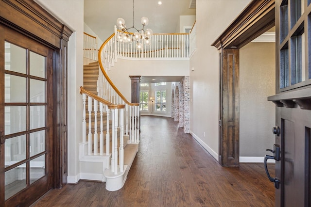 foyer with dark hardwood / wood-style floors, french doors, a high ceiling, and an inviting chandelier